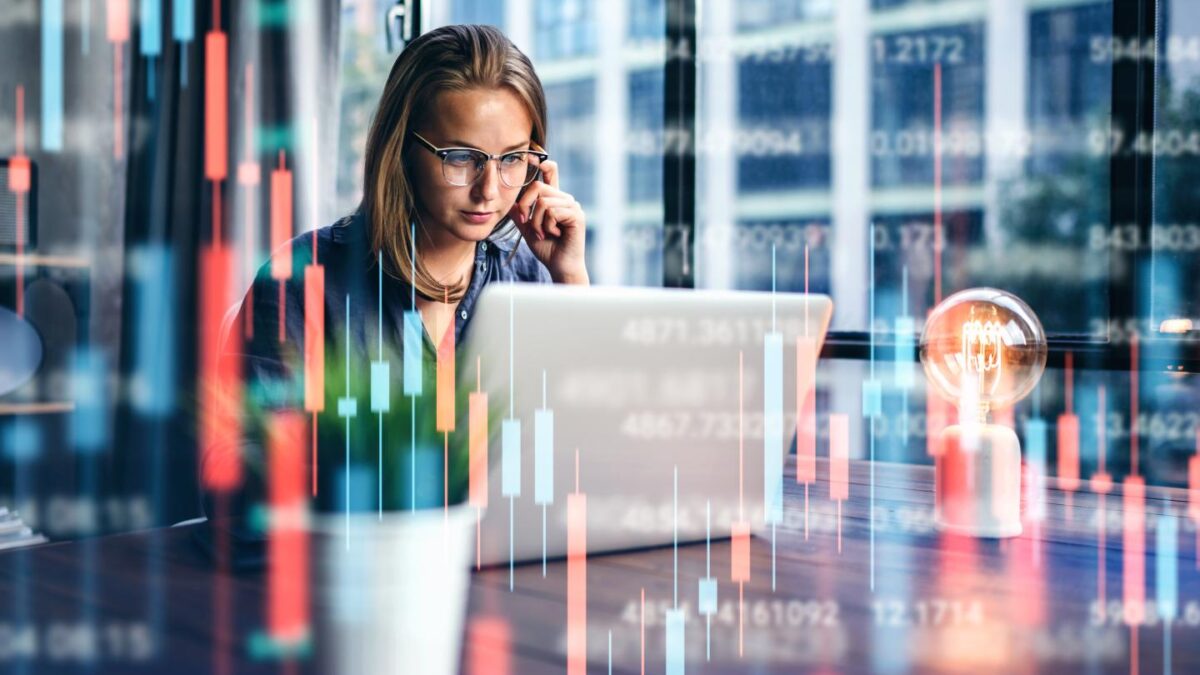 Young woman working at modern office.Technical price graph and indicator, red and green candlestick chart and stock trading computer screen background.