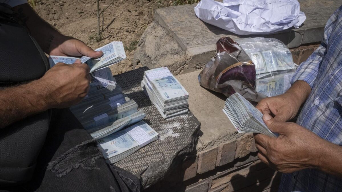 Iranian street money changers count rial banknotes on a sidewalk in downtown Tehran, Sept. 2, 2026.